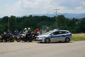 radiowóz kończący przejazd motocyklistów obok zaparkowane motocykle