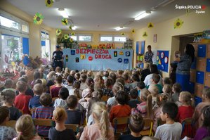 policjantka w czasie wizyty w przedszkolu dzieci siedzą