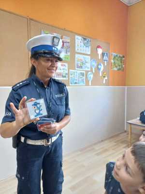 Policjantka stoi pokazuje kartę ze sznupkiem