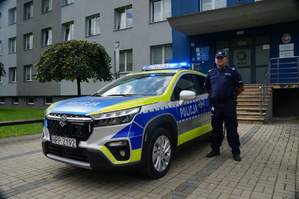 nowy radiowóz zaparkowany przed budynkiem kpp w Żywcu obok stoi policjant