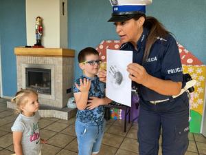 policjantka pokazuje odbitki linii papilarnych