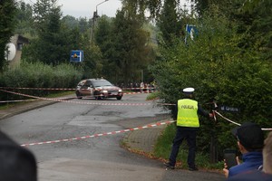 policjant tyłem w tle trasa rajdu i samochód