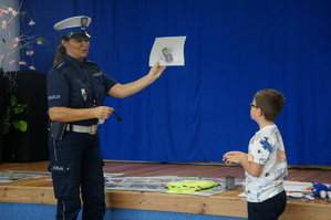 policjantka pokazuje w jaki sposób zabezpiecza się linie papilarne