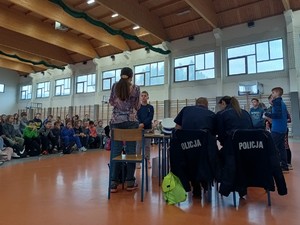 policjanci siedzą tyłem w tle uczniowie