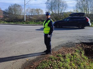 policjantka na skrzyżowaniu kieruje ruchem obok jedzie samochód