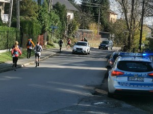 na ulicy stoi radiowóz obok biegacze