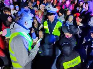 policjantka na zdjęciu z redaktorem podczas udzielania wywiadu wokół stoją osoby