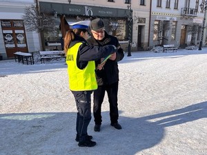 policjantka podczas działań daje mężczyźnie odblask