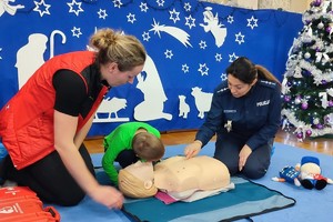 policjantka i ratownik uczą dzieci pierwszej pomocy