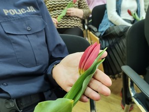 fragment policjantki która trzyma kwiat