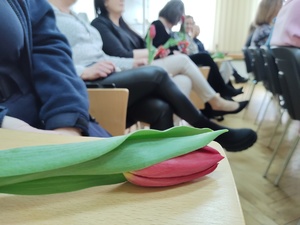 kwiatek leżący na stoliku w tle osoby
