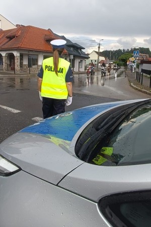 zdjęcie kolorowe policjantka zabezpiecza przejazd motocykli