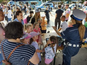 zdjęcie kolorowe policjantka prowadzi konkurs wiedzy dookoła niej dzieci