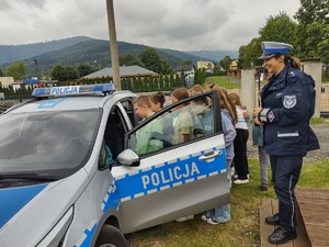 zdjęcie kolorowe dzieci oglądają radiowóz policjantka stoi obok