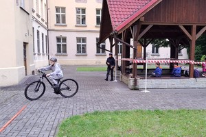 zdjęcie kolorowe zbliżenie na jadącą na rowerze dziewczynkę