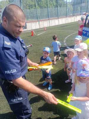 policjant rozdaje dzieciom odblaski