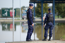 zdjęcie kolorowe policjantka i policjant na tle rozlewiska wodnego