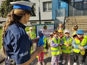 policjantka pokazuje przedszkolakom maskotkę sznupka