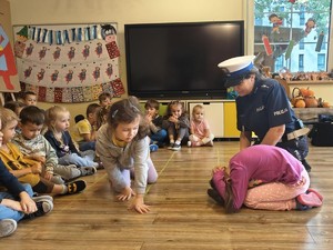 zdjęcie kolorowe policjantka pokazuje jak się zachować w kontakcie z agresywnym psem