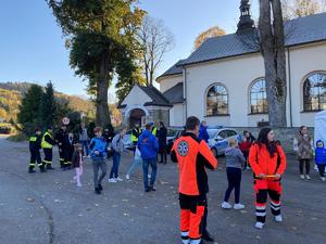 zdjęcie kolorowe przedstawiające ratowników, w tle ludzie i kościół