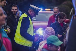 na zdjęciu policjant rozdaje odblaski