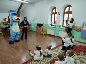 zdjęcie kolorowe policjantka i sznupek który wita się z dziećmi