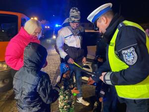 zdjęcie kolorowe policjant wręcza odblaski