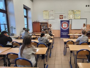 zdjęcie kolorowe uczniowie siedzą w ławkach i piszą test