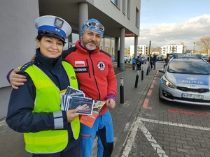 zdjęcie kolorowe policjantka z ratownikiem obok radiowóz