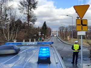 fragment radiowozu w tle policjant i biegacze