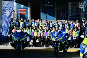 zdjęcie kolorowe uczniowie stoją na schodach przed budynkiem komendy