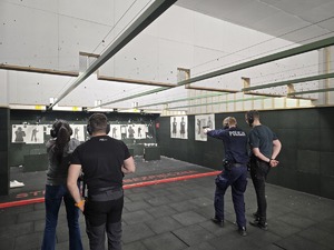 policjanci podczas strzelania obok stoją instruktorzy