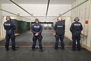 czterech policjantów stoi tyłem przygotowują się do strzelania