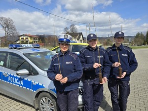 trzy policjantki stoją obok siebie i trzymają sadzonki