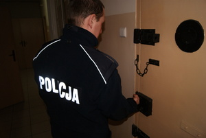 zdjęcie poglądowe policjant zamyka drzwi do pomieszczenie dla osób zatrzymanych
