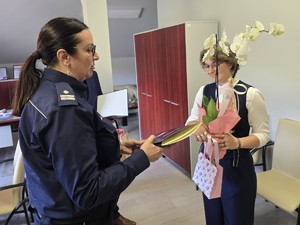 komendant powiatowa wręcza kwiaty i upominek