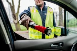 zdjęcie poglądowe policjant podczas badania stanu trzeźwości kierowcy