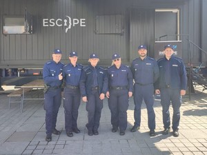 policjanci stoją obok siebie przed escaptruckiem