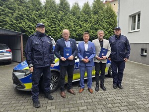 wójtowie stoją na tle radiowozu