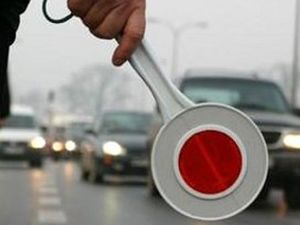 zdjęcie poglądowe na pierwszym planie tarcza do zatrzymywania pojazdów w tle ulica i samochody