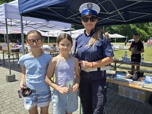 policjantka z dwoma dziewczynkami które wygrały nagrody
