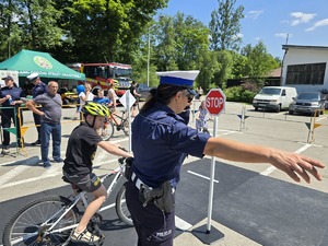 policjantka z dzieckiem na rowerowym miasteczku ruchu drogowego
