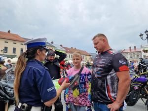 policjantka wręcza kamizelkę motocykliście