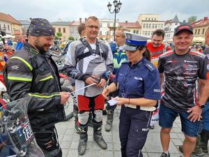 policjantka rozdaje motocyklistą odblaski