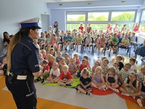 policjantka stoi przed dziećmi zdjęcie zrobione z boku
