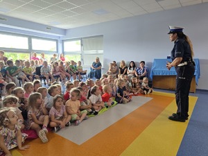 policjantka stoi przed dziećmi zdjecie zrobione z boku