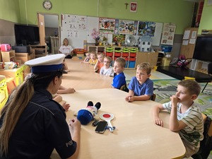 policjantka siedzi przy stole z przedszkolakami