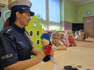 policjantka z ratusiem dzieci siedzą obok