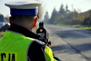 policjant tyłem z urządzeniem do pomiaru prędkości
