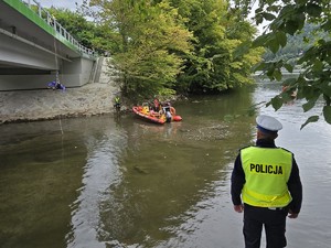 zdjęcie kolorowe, policjant na brzegu jeziora